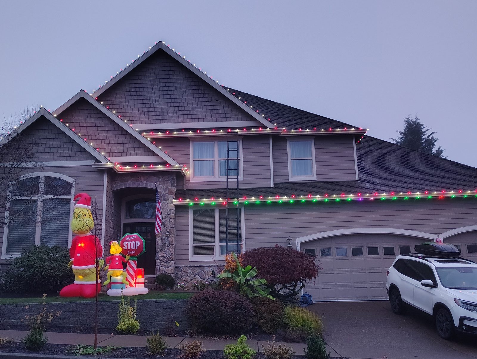 HomeHaven Christmas lights installed along the roofline of a gray two-story Portland home in November 2025